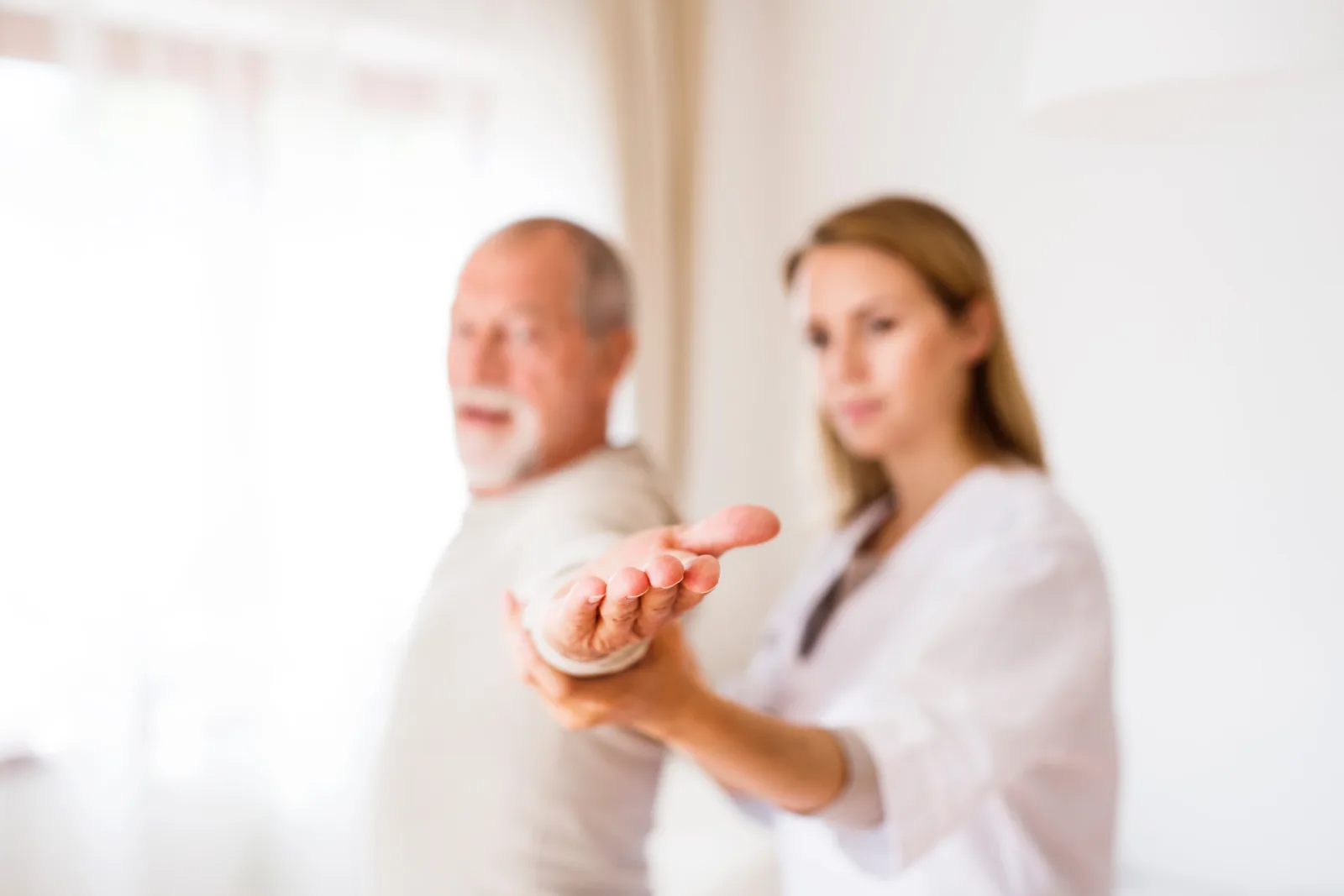 Physiotherapeut bespricht die Behandlung mit einem Patienten in der Praxis